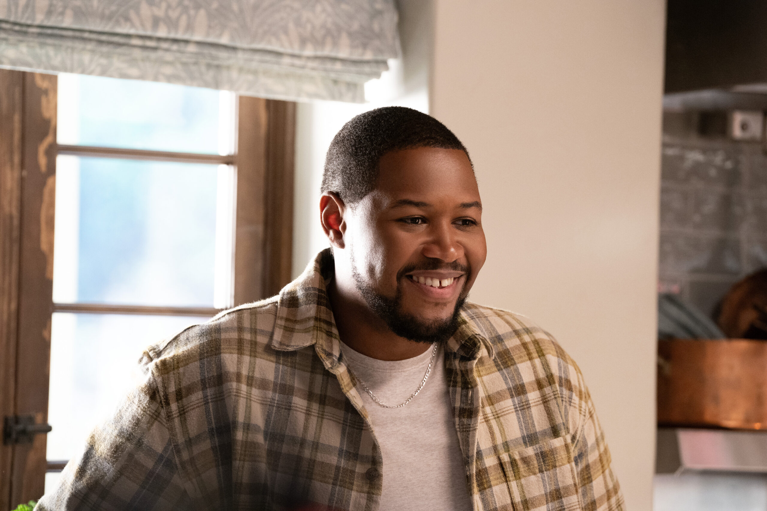 Shrinking Season 2 Episode 3 Psychological Something-ism | Tell-Tale TV Sean smiles while standing in a brightly lit kitchen on Shrinking Season 2 Episode 3, "Psychological Something-ism."