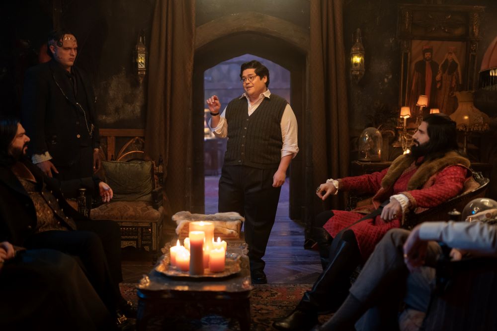 Guillermo stands in the living room of a dimly lit house on Staten Island on What We Do in the Shadows Season 6 Episode 4, "The Railroad."