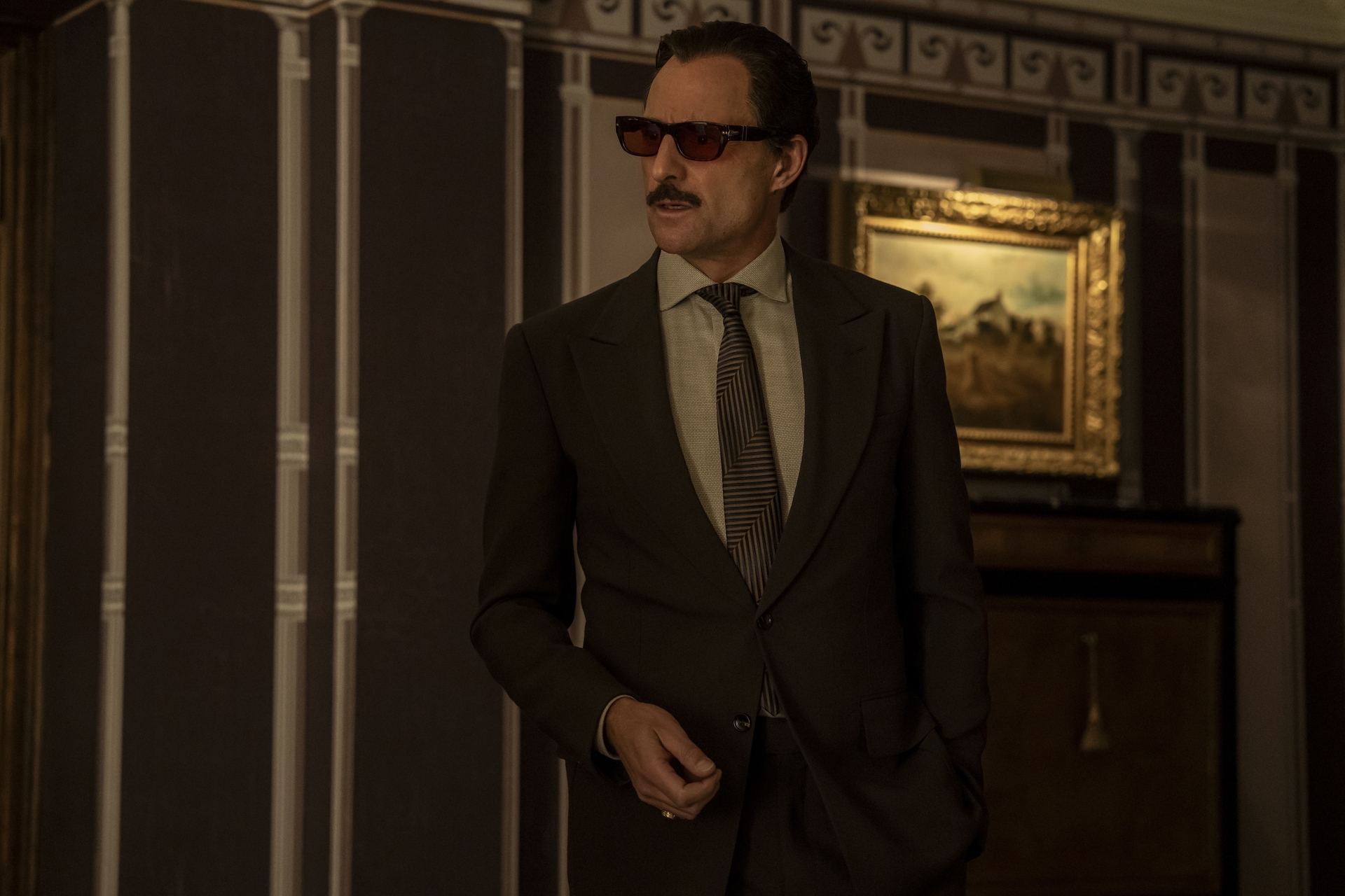 The Penguin Season 1 Episode 4 - Mark Strong | Tell-Tale TV Still from The Penguin Season 1 Episode 4 of Mark Strong wearing a suit and a pair of sunglasses.