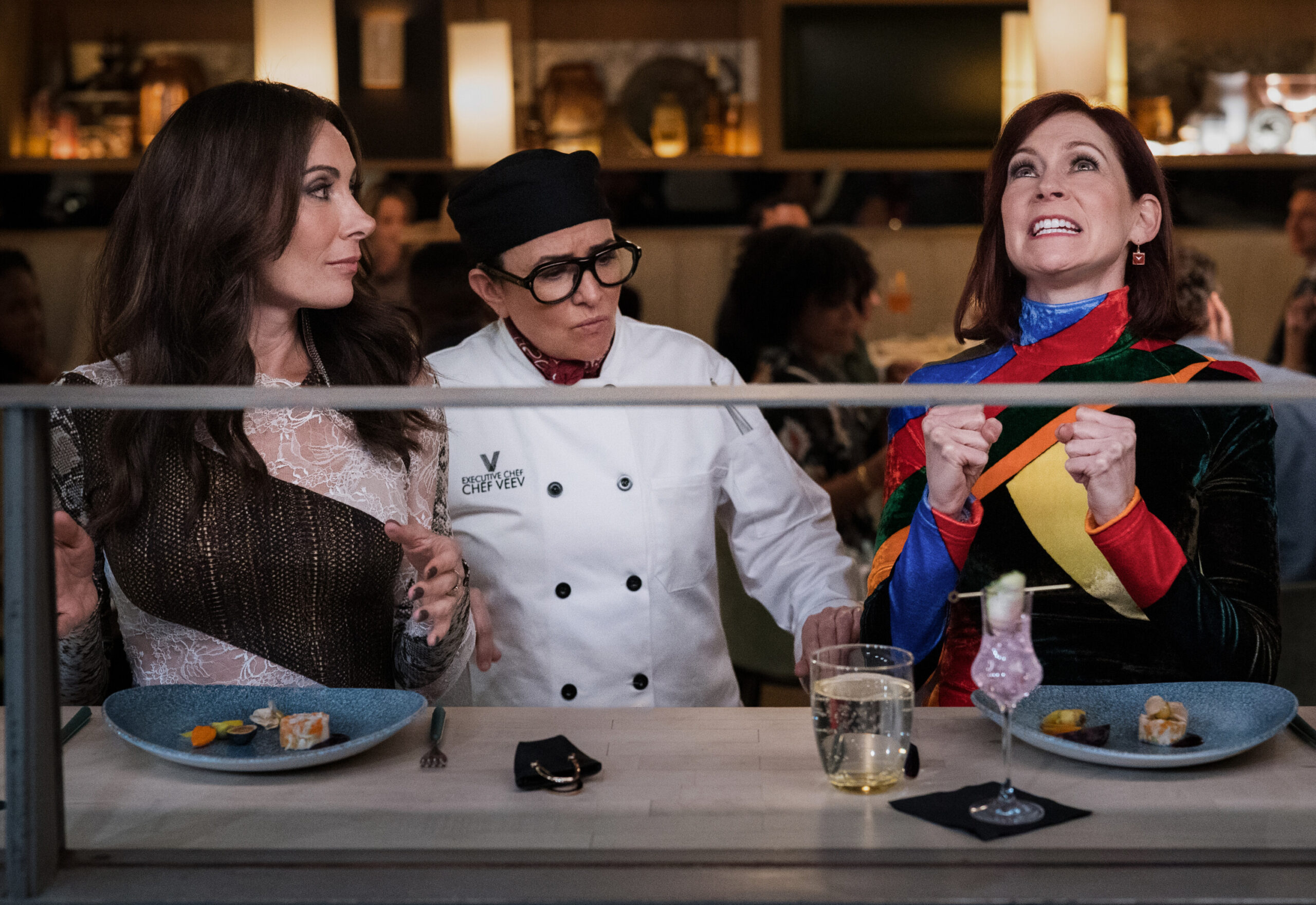 Still from Elsbeth Season 2 Episode 5 of Lauren Benanti as Nadine Clay, Pamela Adlon as Chef Z, and Carrie Preston as Elsbeth Tascioni pictured from left to right.