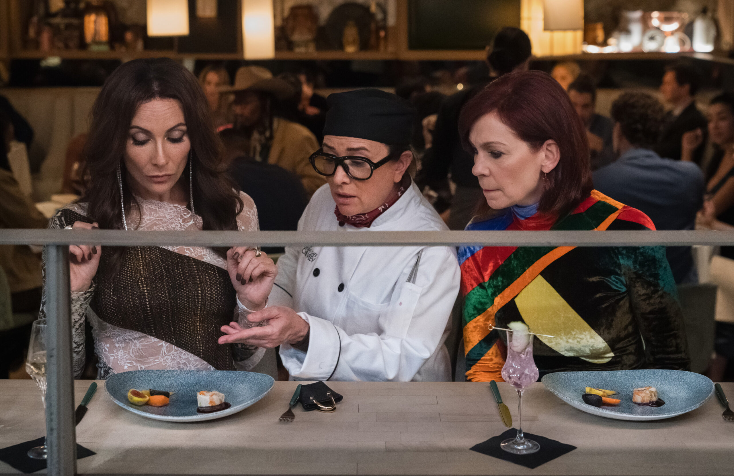 Still from Elsbeth Season 2 Episode 5 of Lauren Benanti as Nadine Clay, Pamela Adlon as Chef Z, and Carrie Preston as Elsbeth Tascioni pictured from left to right.