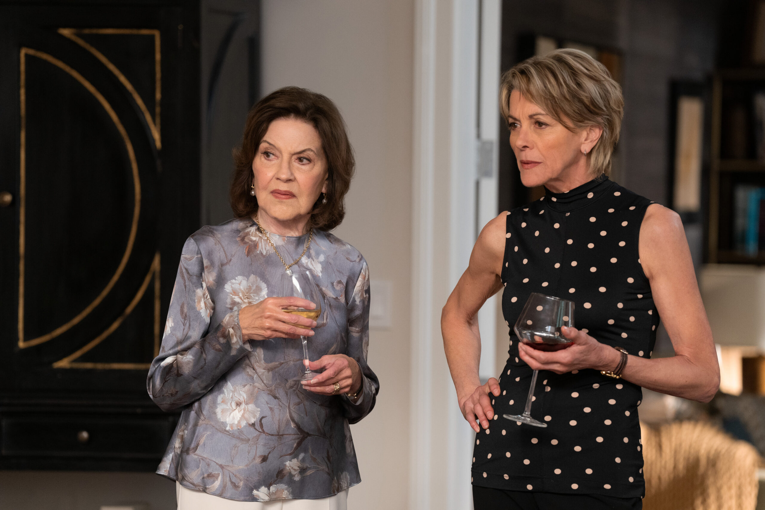 Susan and Julie stand in a living room while holding wine glasses on Shrinking Season 2 Episode 5, "Honesty Era."