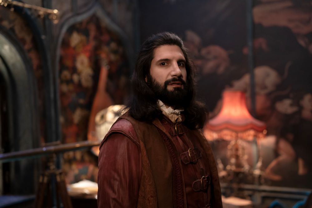 A closeup of Nandor as he stands in a dimly lit room in an old house on What We Do in the Shadows Season 6 Episode 6, "Laszlo's Father."