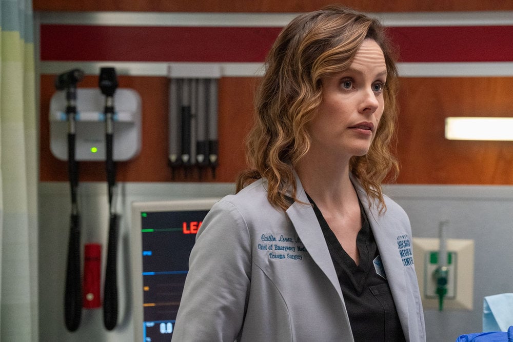Sarah Ramos as Dr. Caitlin Lenox in a hospital room.