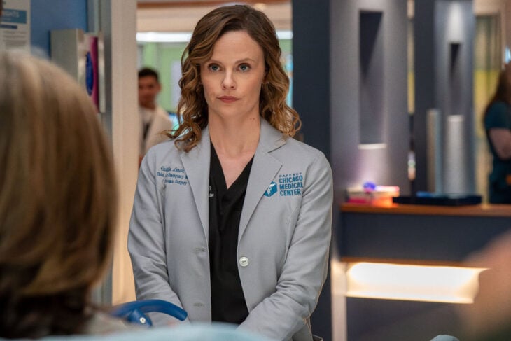 Sarah Ramos as Dr. Caitlin Lenox standing in the hospital room.
