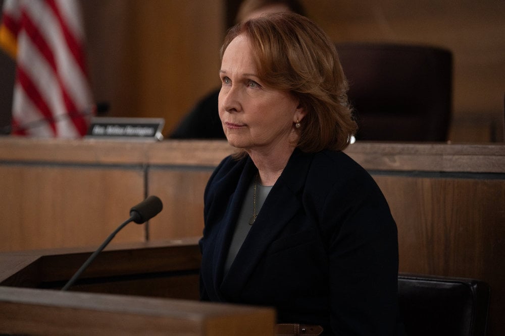 Kate Burton as Dr. Allen sitting on the stand.