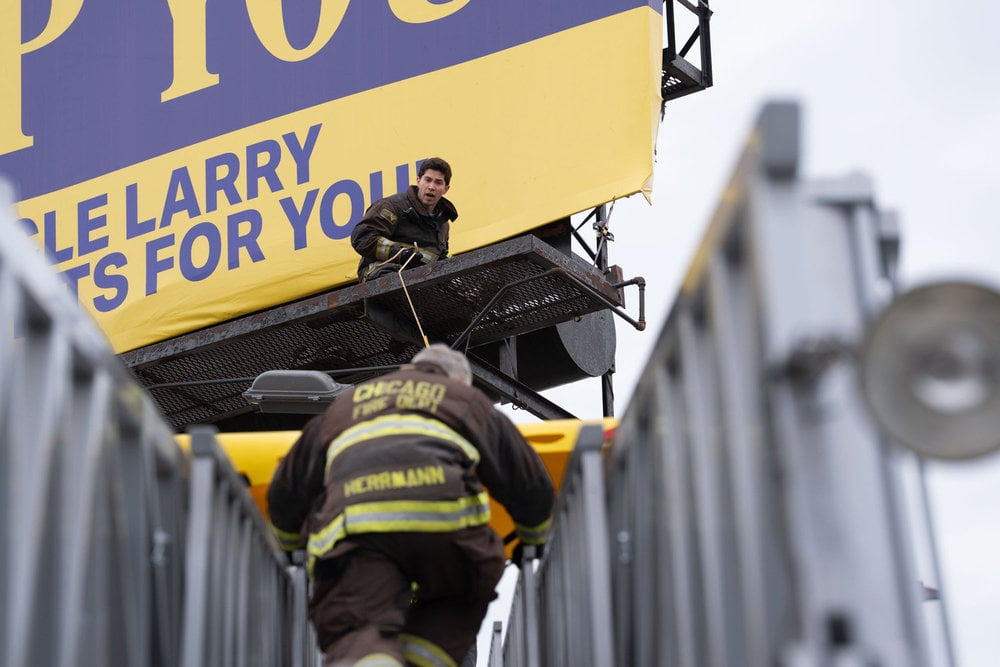 Brandon Larracuente as Sal Vasquez helping lower a teammate into a scene.