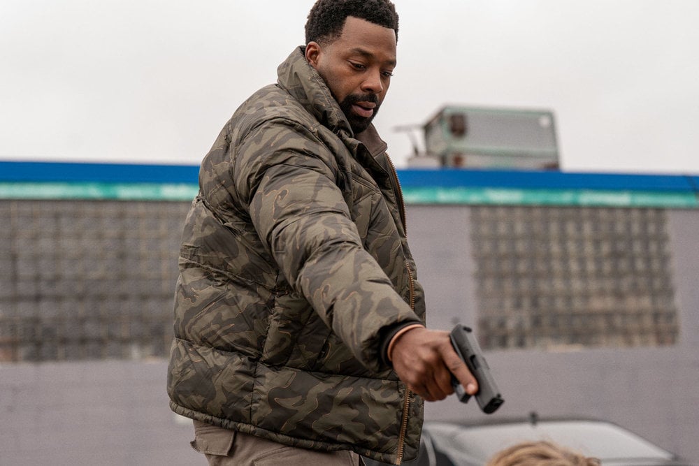 LaRoyce Hawkins as Officer Kevin Atwater pointing down at someone with his gun.