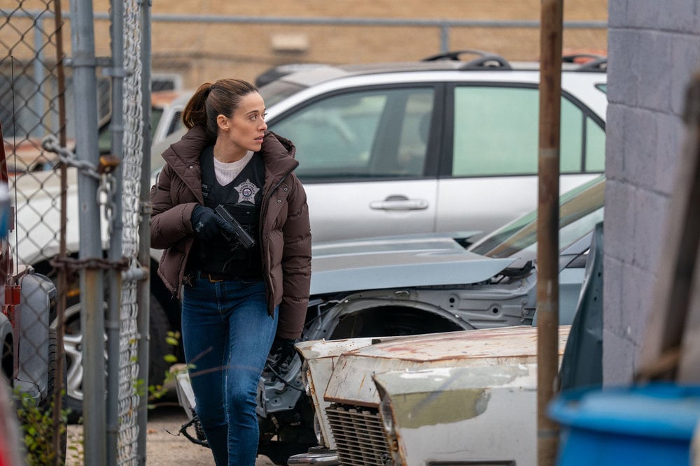 Marina Squerciati as Officer Kim Burgess walking on the street with his gun out.