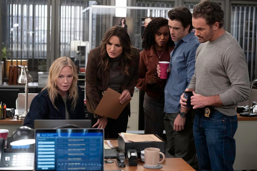 Kelli Giddish as Sgt. Amanda Rollins, Mariska Hargitay as Capt. Olivia Benson, Aimé Donna Kelly as Capt. Renee Curry, Corey Cott as Det. Jake Griffin, Kevin Kane as Det. Terry Bruno in the squad room looking at a computer.