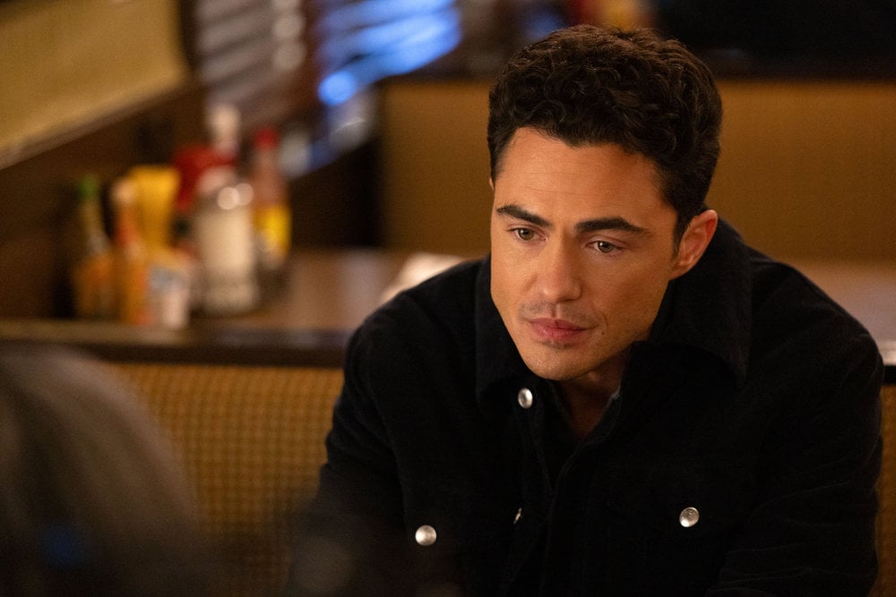 Darren Barnett como Dr. John Frost sentado em um bar.