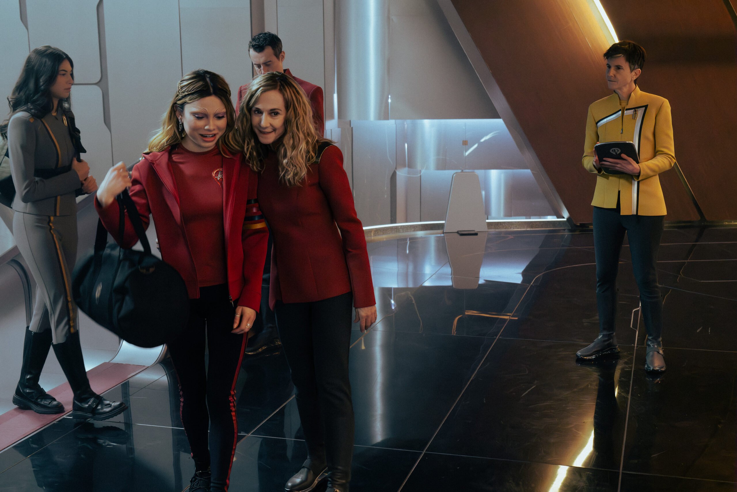 Uma foto de Star Trek: Starfleet Academy, temporada 1, episódio 7. Na foto da esquerda para a direita estão Bella Shepard como Genesis, Holly Hunter como Capitão Nahla Ake e Tig Notaro como Reno.