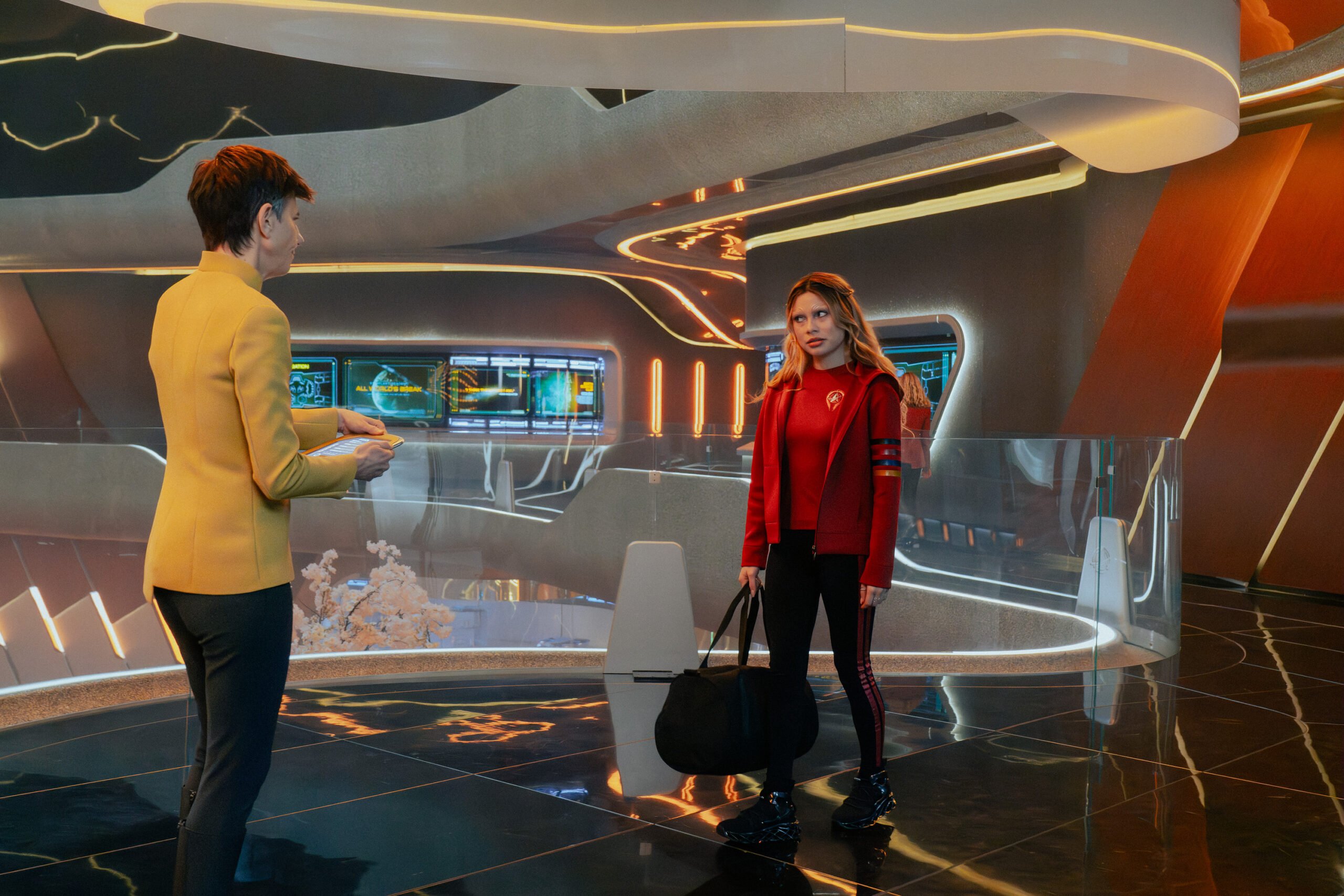 Still de Star Trek: Starfleet Academy, temporada 1, episódio 7. Na foto da esquerda para a direita estão Tig Notaro como Reno e Bella Shepard como Genesis.