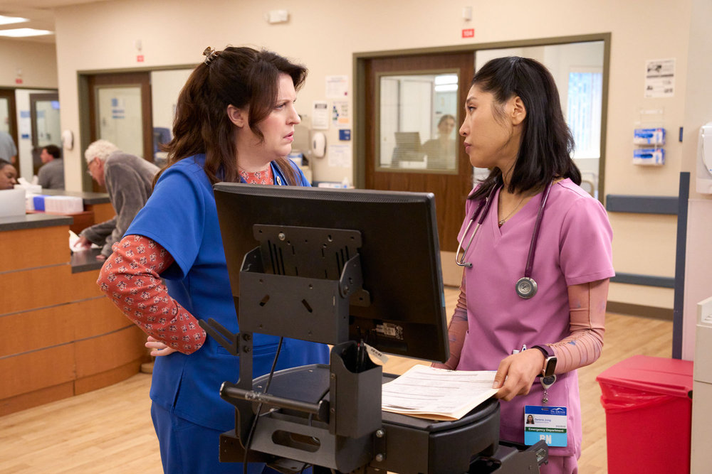 Allison Tolman como Alex e Kaehyun Kim como Serena no episódio 12 da 2ª temporada de St. Denis Medical, Consentimento e Consentimento.