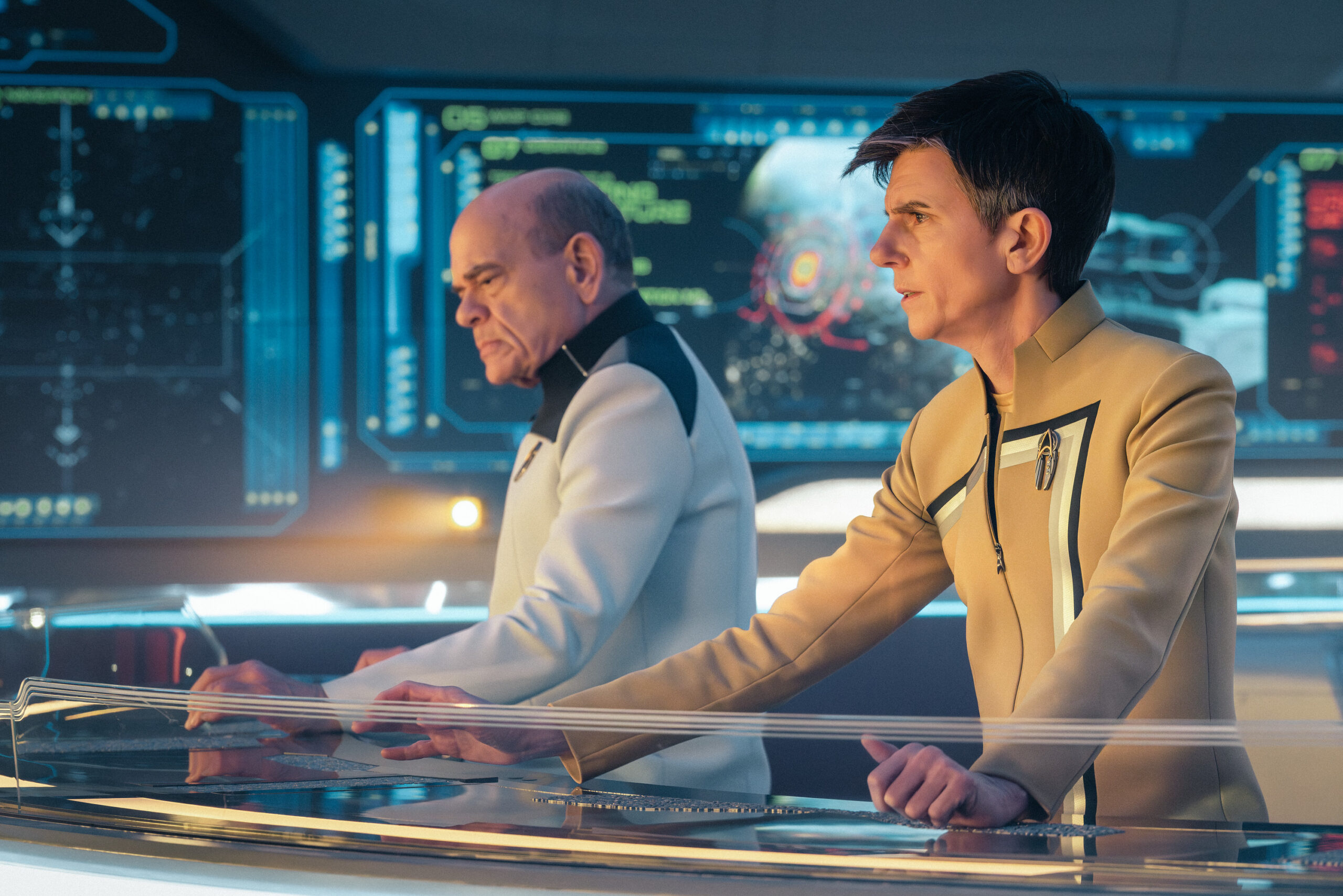 Star Trek: Starfleet Academy Season 1 Episode 9 - Robert Picardo and Tig Notaro | Tell-Tale TV Still from Star Trek: Starfleet Academy Season 1 Episode 9, 300th Night, of Robert Picardo as The Doctor and Tig Notaro as Reno pictured from left to right
