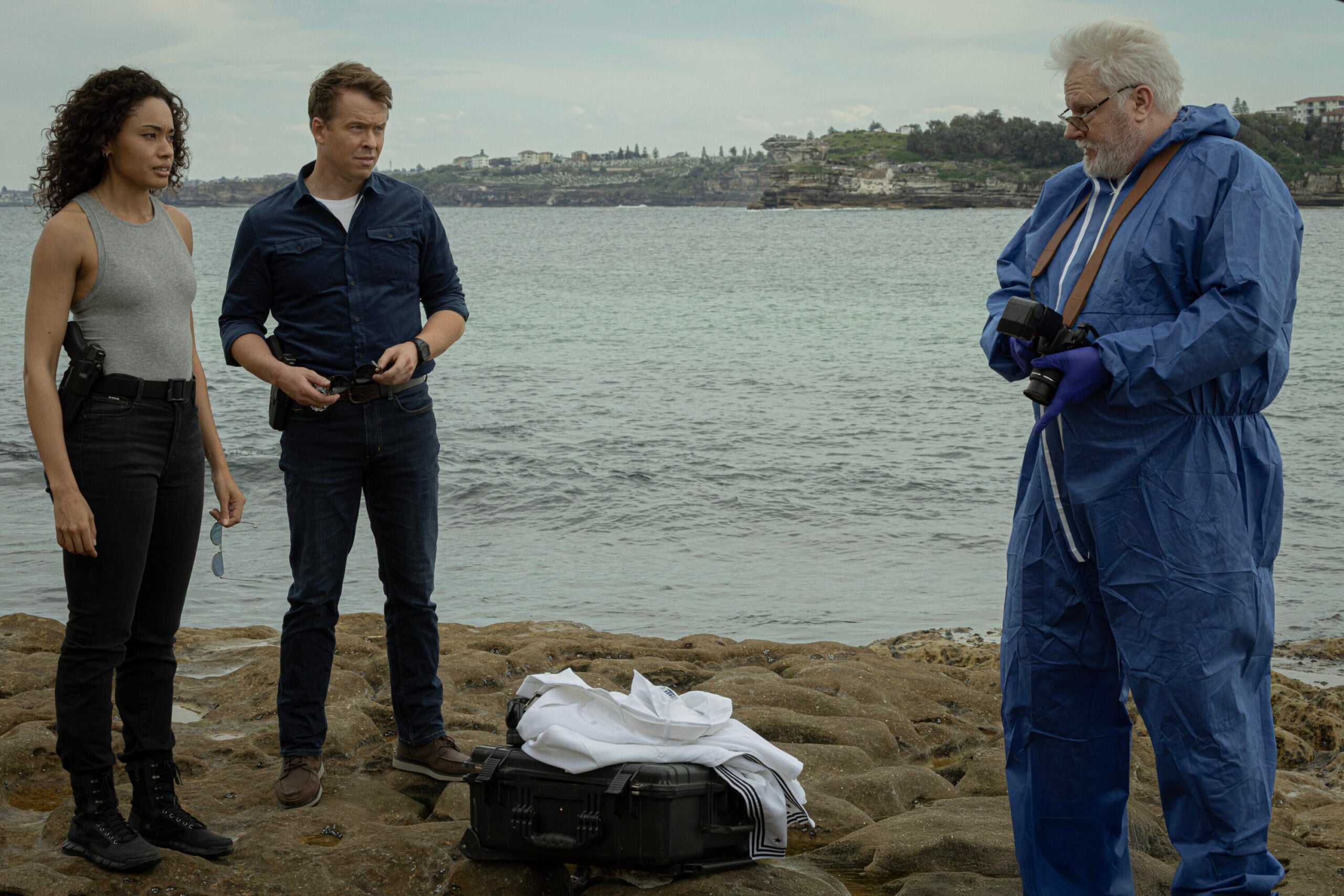 NCIS: Sydney Season 3 Episode 14, "Death Card" -- Olivia Swann as NCIS Special Agent Captain Michelle Mackey, Todd Lasance as AFP Liaison Officer Sergeant Jim 'JD' Dempsey and William McInnes as Forensic Pathologist Dr. Roy Penrose